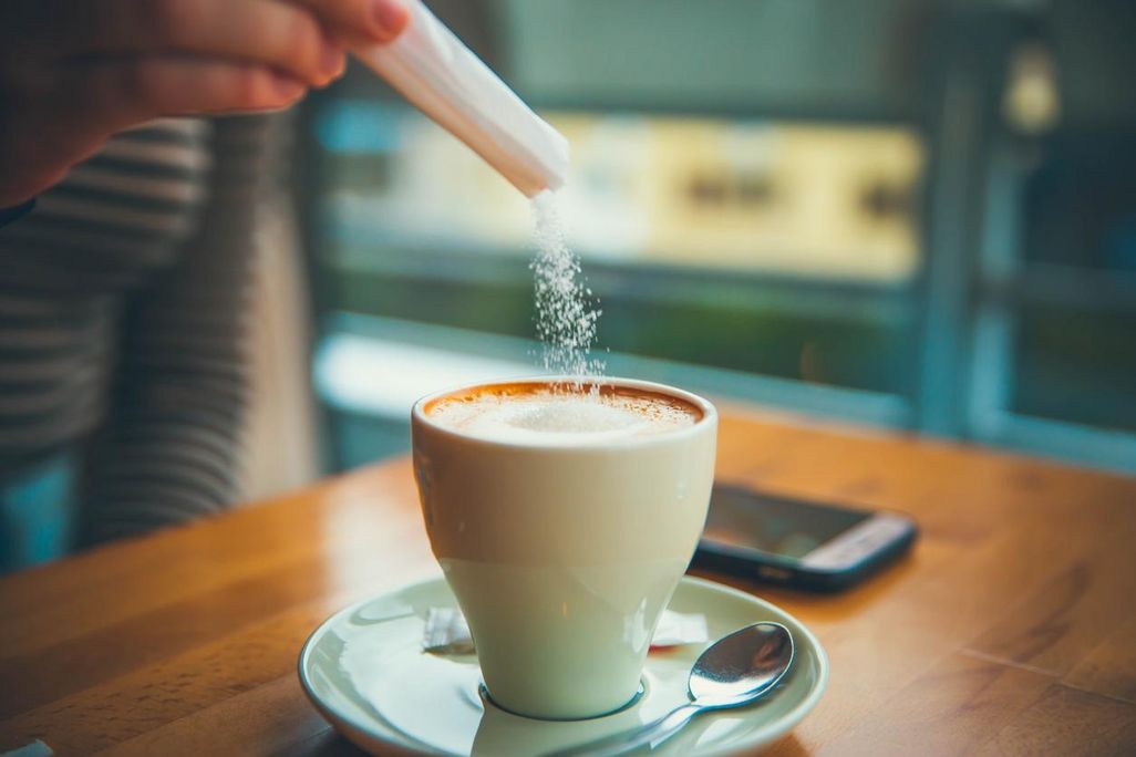 Tatsächlich Zucker in den Kaffee gießen.