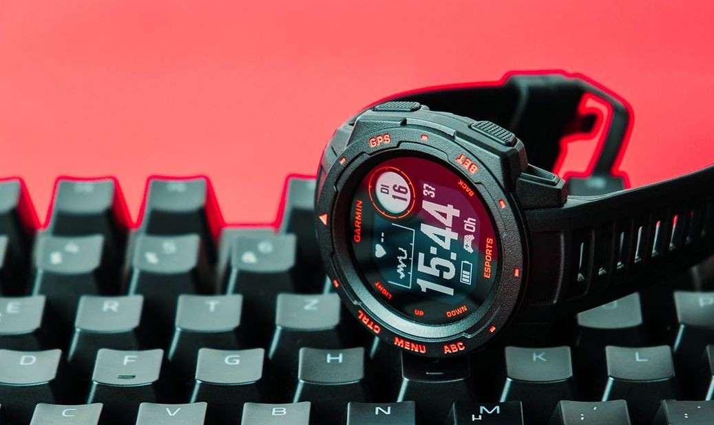 Smartwatch Garmin Instinct Esports liegt auf Tastatur