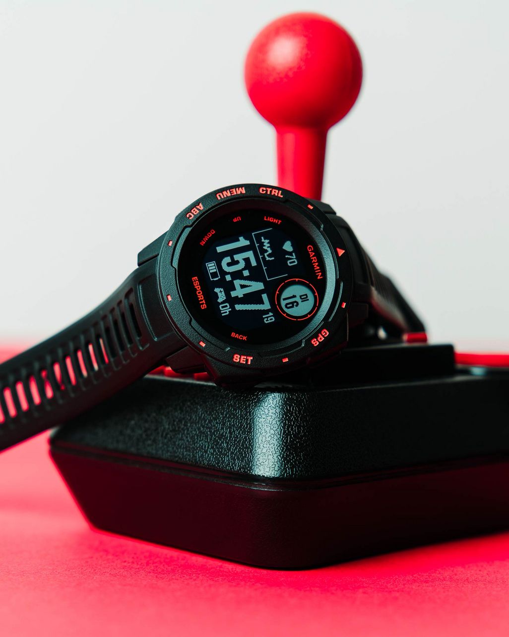 Die Smartwatch Garmin Instinct Esports liegt auf Joystick