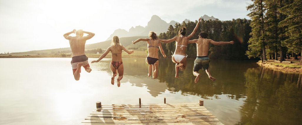 Freunde springen gemeinsam in den See